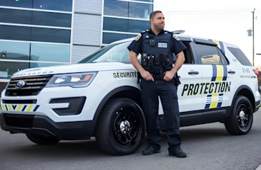 Physical Security Guard Standing in front of Security Car wearing security technology